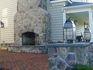 Lighted pillar with stone veneer and two-story outdoor fireplace